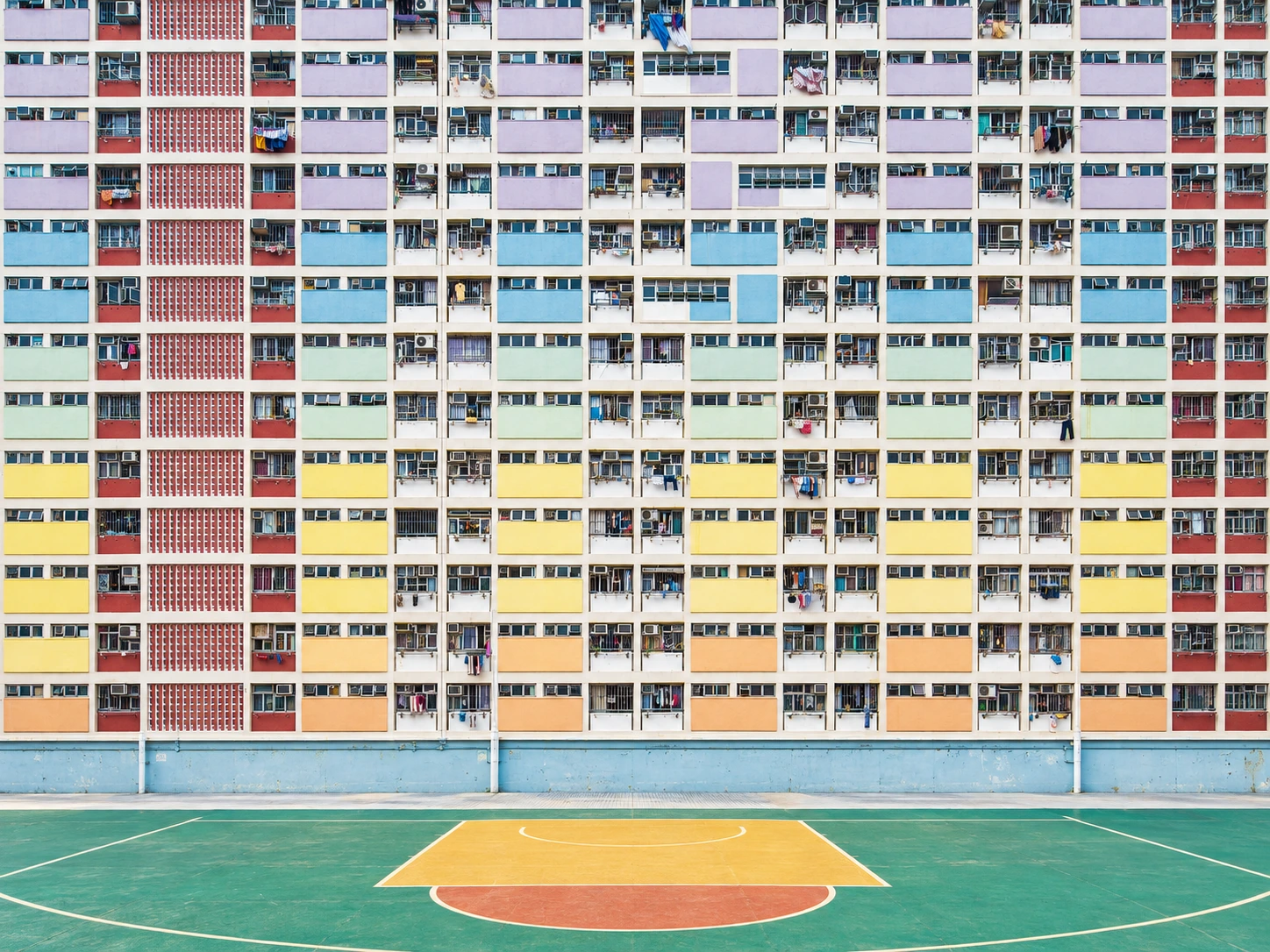 A real-world-inspired pastel Kowloon estate overlooking a colourful court in daylight