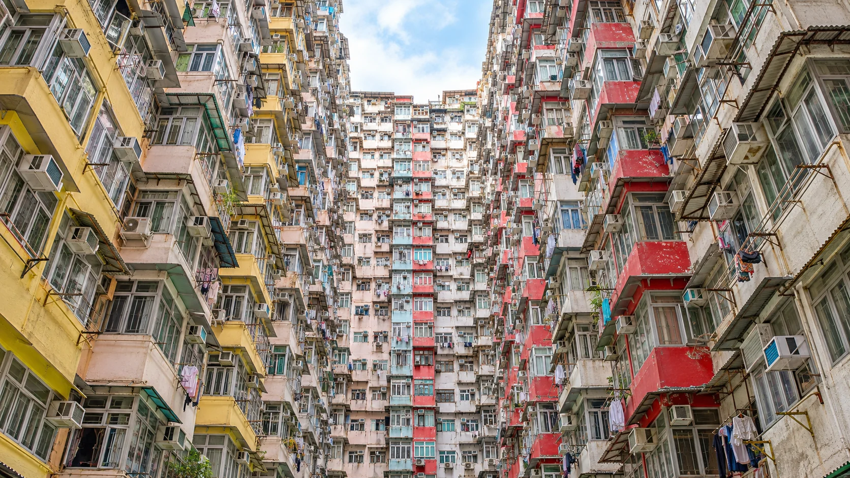 Looking up through the colourful, densely packed apartments of the Monster Building